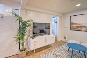 a living room with a tv and a table and a plant at Rockaway Beach Condo - Beach Access Nearby! in Rockaway Beach