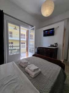 sypialnia z łóżkiem z dwoma ręcznikami w obiekcie Hall Apartments & Rooms - by Avelink w mieście Spata