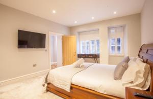 um quarto com uma cama grande e uma televisão de ecrã plano em Stylish 2 Bedroom Apartment In Park Circus, West End em Glasgow