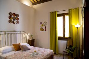 a bedroom with a bed with green curtains and a window at B&B Sabir in San Vito lo Capo