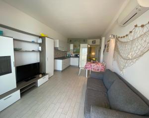 a living room with a couch and a television at Appartamento Tramonto in Castelsardo