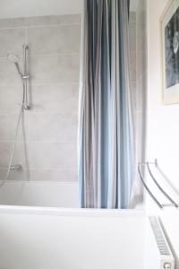 a bathroom with a shower curtain and a bath tub at The Lookout in Cellardyke +56 photos