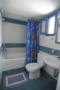 a bathroom with a toilet and a tub and a sink at Karavostassi - The Stonehouse in Agios Nikolaos