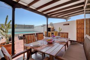 Un comedor con mesa y sillas de madera. en Villa Mar, en Teguise