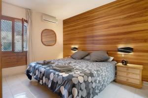 Un dormitorio con una cama y una pared de madera. en Villa Mar, en Teguise 17 fotos más