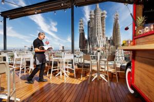 a man standing on a deck with a view of the city at Sercotel Hotel Rosellon in Barcelona