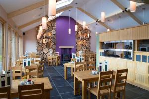 a restaurant with wooden tables and chairs and a fireplace at Tawny Cottage in Portinscale