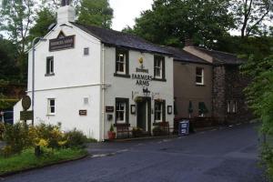 a white building sitting on the side of a street at Tawny Cottage in Portinscale