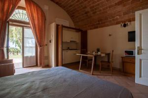 a bedroom with a bed and a table and a kitchen at Appartamento Pianosa in Riotorto