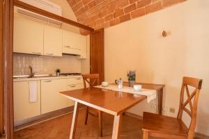 a small kitchen with a wooden table and chairs at Appartamento Pianosa in Riotorto