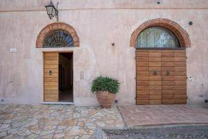 a building with two wooden doors and a potted plant at Appartamento Giglio in Riotorto