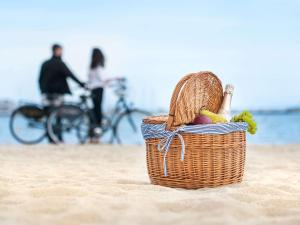 una cesta de fruta en la arena de una playa en Rezydent Sopot MGallery Hotel Collection en Sopot