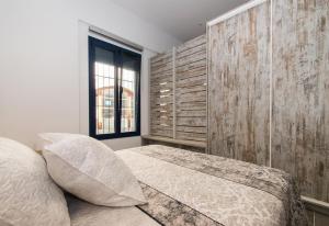 een slaapkamer met een bed en een raam bij Petit Loft in Canet de Mar +17 foto's