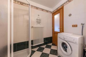 une buanderie avec une machine à laver et une douche dans l'établissement Ciasa Sommavilla Calendula, à Vigo di Fassa