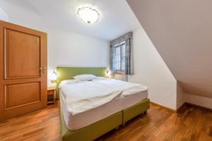 1 dormitorio con cama y escalera en Ciasa Sommavilla Calendula, en Vigo di Fassa
