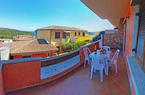 eine Terrasse mit einem Tisch und Stühlen auf dem Balkon in der Unterkunft Residence Eolo in Porto Pozzo
