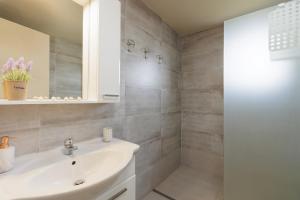 a bathroom with a white sink and a shower at Mythos Modern Loft in Dassia +8 photos