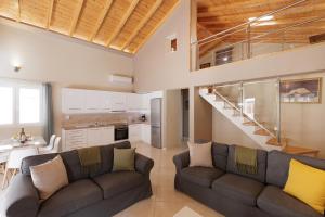 a living room with two couches and a staircase at Mythos Modern Loft in Dassia