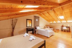 two beds in a room with wooden ceilings at Mythos Modern Loft in Dassia
