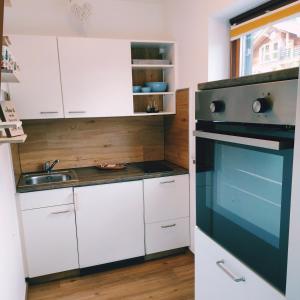 a kitchen with white cabinets and a black oven at Ferienwohnung Bergblume in Bolsterlang +5 photos