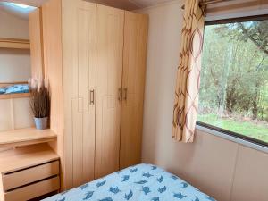 1 dormitorio con cama y ventana en 95 Newquay bay Resort Dog friendly, en Newquay