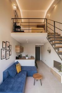 a living room with a blue couch and a staircase at Stylish & elegant loft suite in the city center in Zakynthos