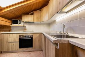 a kitchen with a sink and a microwave at Ciasa Sommavilla Mansarda in Vigo di Fassa