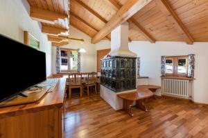 a living room with a fireplace and a dining room at Ciasa Sommavilla Mansarda in Vigo di Fassa