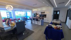 una cocina y una sala de estar con mesas azules y un hombre en Villa Luxury - Finest luxury villa in Sosua & Puerto Plata, en Juan de Nina Muñoz