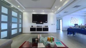 uma sala de estar com uma grande televisão na parede em Villa Luxury - Finest luxury villa in Sosua & Puerto Plata em Juan de Nina Muñoz