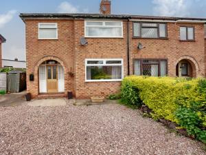 a brick house with a white door at The Hawthorns in Chester