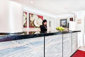 a woman standing behind a counter in a room with paintings at West Edmonton Mall Inn in Edmonton +28 photos