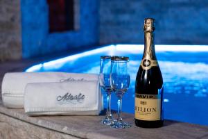 a bottle of champagne and a glass next to a pool at Adriatic Spa in Novi Sad