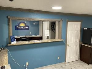 a room with a blue wall and a mirror at Days Inn by Wyndham Pratt in Pratt