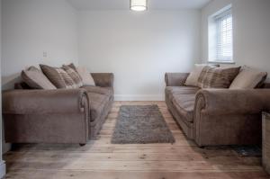 a living room with two couches and a rug at West Jordanston Farm Cottage - 4 Bedroom Cottage - St Florence in Tenby