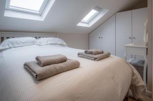 um quarto com uma cama branca com duas toalhas em West Jordanston Farm Cottage - 4 Bedroom Cottage - St Florence em Tenby
