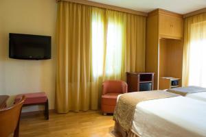 a hotel room with a television and a bed at Los Angeles Hotel & Spa in Granada