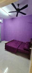 マサイにあるHomestay Layangの紫色のベッドルーム(紫色のベッド1台、天井ファン付)