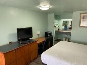 a bedroom with a bed and a tv on a dresser at Days Inn by Wyndham Pratt in Pratt