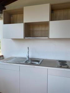 uma cozinha com armários brancos e um lavatório em My Tiffany Condo em Tanaunella