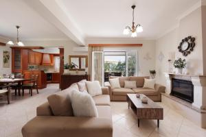 a living room with a couch and a table at Villa Mythos with Infinity Pool in Dassia
