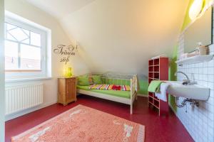 una camera per bambini con un letto verde e un lavandino di Ferienhaus Zaunkönig a Eversmeer