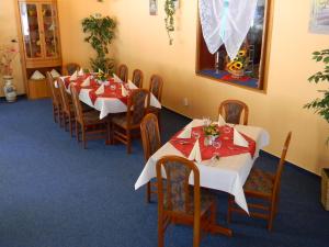 エーレントにあるHotel Waldmühleのダイニングルーム(テーブル、椅子、赤と白のテーブルクロス付)