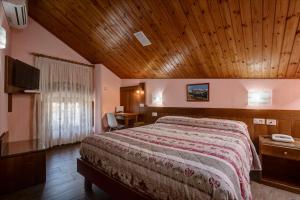ein Schlafzimmer mit einem großen Bett und einer Holzdecke in der Unterkunft Hotel Cecchin in Aosta
