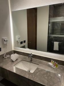 a bathroom with a sink and a large mirror at Gumont Guadalajara López Mateos - Minerva in Guadalajara