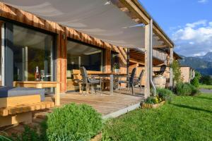 una terraza de madera con mesa y sillas en una casa en Ferienlodge MaResi en Bad Goisern