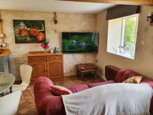 a living room with a couch and a flat screen tv at Stable Cottage "The Unicorn Stable" in Yelverton