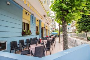 a row of tables and chairs outside of a building at HOTEL CLARA RIMINI 30m from the beach in Rimini