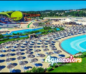 a beach with umbrellas and a water park at Apartment Alina in Umag