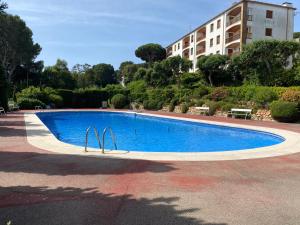 a large blue swimming pool in front of a building at Apartamento con espectaculares vistas al Mediterráneo in Calella de Palafrugell